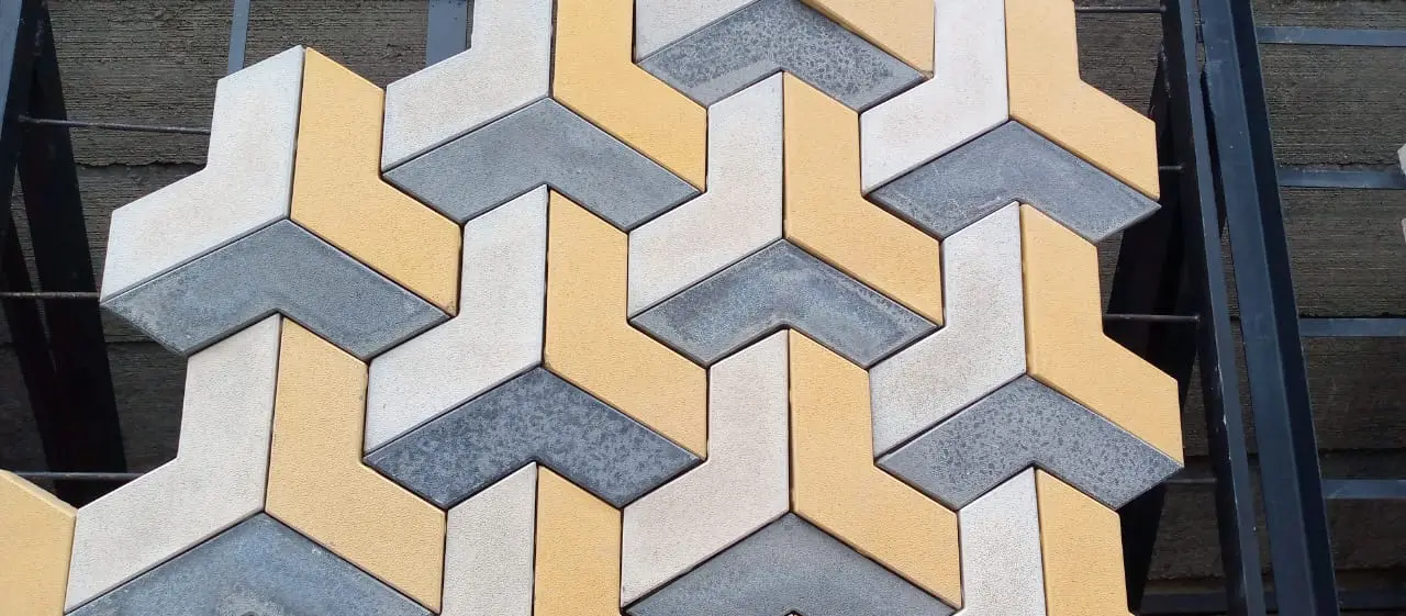 Close-up of yellow, white and grey pavers laid in a 3D pattern